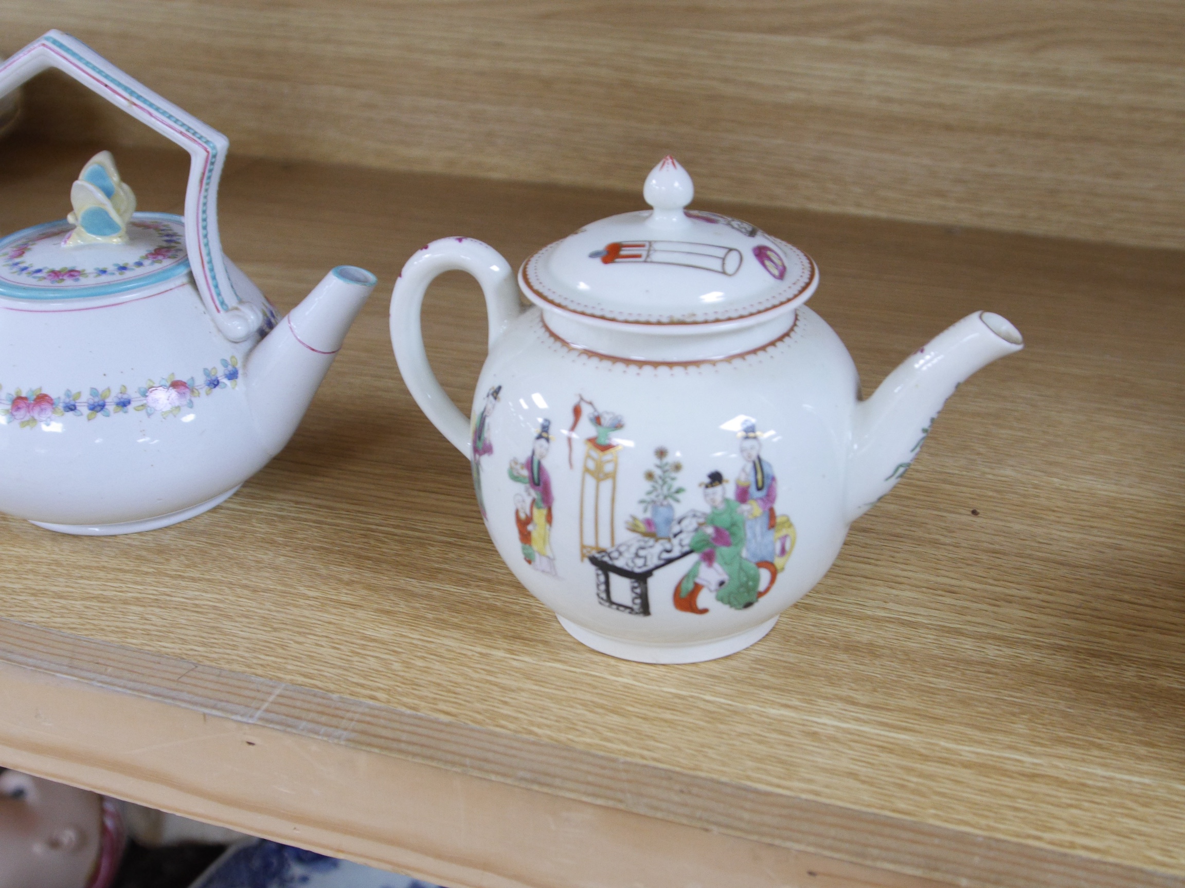 A Worcester chinoiserie teapot, c.1770 and a Victorian teapot with decorative butterfly cover, chinoiserie teapot 16cm high. Condition - damage to rim of Victorian teapot.